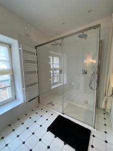 uma casa de banho com um chuveiro e um tapete preto em Duplex de charme à Lessy em Lessy
