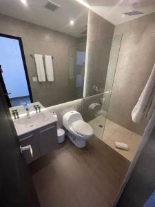 een badkamer met een toilet, een wastafel en een douche bij AmazINN Places Rooftop and Design Pool III in Panama-Stad