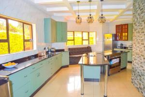 a large kitchen with blue cabinets and windows at Mt Pleasant - 4-Bed Villa in Harare Solar Power in Kingsmead