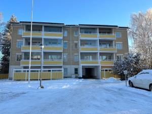 an apartment building with a parking lot in the snow at Apartment Ahkiomaantie in Rovaniemi