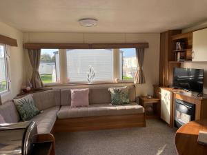a living room with a couch and a television at Captivating 2-Bed Caravan in Clacton-on-Sea in Clacton-on-Sea
