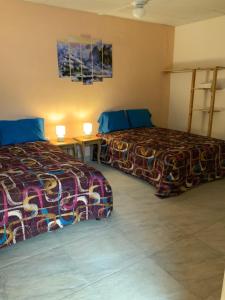 pokój hotelowy z 2 łóżkami i stołem w obiekcie LA DOLCE VITA FRANCOPHONE w mieście Estelí