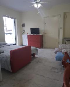 a bedroom with two beds and a tv and a dresser at Daisy luxury in Piraeus