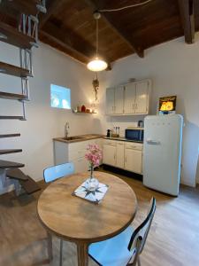 een keuken met een tafel en een witte koelkast bij Duplex de charme à Lessy in Lessy