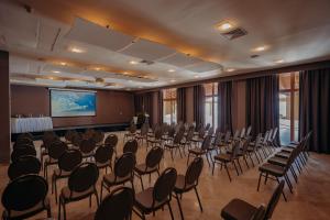 une salle de conférence avec des chaises et un écran de projection dans l'établissement The Bannister Hotel & Yacht Club by Mint, à Santa Bárbara de Samaná