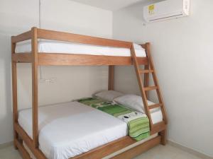 Cabañas del caribe في Coveñitas: سريرين بطابقين في غرفة بها مشعاع