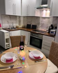 una cocina con una mesa con una botella de vino y copas en Tóvölgy Privát Vendégház, en Pécsvárad