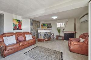 a living room with two leather couches and a fireplace at Villa Soledad en Olivella, Sitges, Barcelona in Olivella