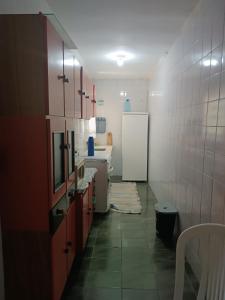 uma cozinha com um frigorífico branco e um piso em Casa aconchegante beira mar em Mongaguá