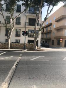 an empty street in front of a building at Room in Trilithon Court Apartments Ghaxaq in Hal Ghaxiak