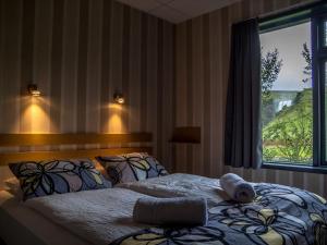 a bedroom with a large bed with a window at Hótel Skógafoss by EJ Hotels in Skogar