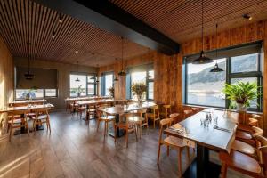 un restaurante con mesas, sillas y ventanas en Hótel Skógafoss by EJ Hotels en Skogar