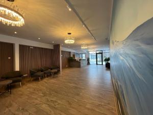 vestíbulo con sala de espera con sillas y lámpara de araña en Hótel Skógafoss by EJ Hotels, en Skogar