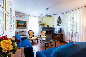 a living room with blue furniture and a fireplace at Villa Donnafugata in Santa Domenica
