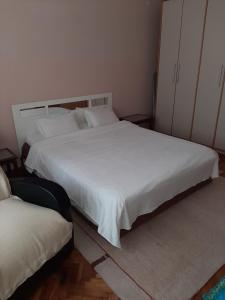 um quarto com 2 camas e lençóis brancos em Anka em Jagodina