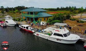 3 barche sono ormeggiate in un molo con un edificio di Bella Vita Casitas a Placencia