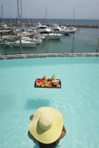 une personne dans un chapeau dans l'eau avec un bateau dans l'établissement The Bannister Hotel & Yacht Club by Mint, à Santa Bárbara de Samaná