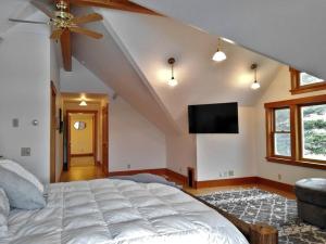 a bedroom with a large bed and a flat screen tv at Beautiful 1910 American Craftsman home, close to Bozeman Hot Springs, near Bozeman and Big Sky, Montana. in Gallatin Gateway
