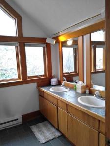 a bathroom with two sinks and two mirrors at Beautiful 1910 American Craftsman home, close to Bozeman Hot Springs, near Bozeman and Big Sky, Montana. in Gallatin Gateway