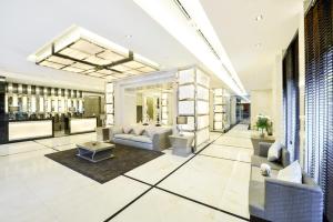 a lobby with couches and tables and a bar at Centre Point Chidlom in Bangkok
