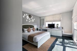 a bedroom with a large bed and a kitchen at Alba Spa Hotel in Hue