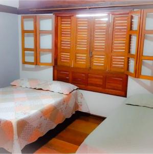 a bedroom with wooden cabinets and a bed in it at Casa Charmosa Em Bonito in Bonito