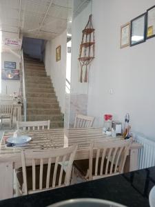 a dining room with a table and chairs and stairs at Çiftlik otel 