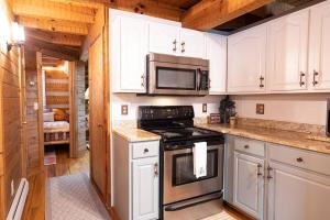 uma cozinha com armários brancos e um forno com placa de fogão em O'Harrah's Hundred em Grantsville