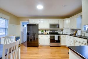 cocina con armarios blancos y nevera negra en Pet-Friendly Cottage 8 Mi to Paul Bunyan Land!, en Brainerd