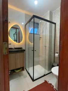 卡姆布庫的住宿－Casa Amar Cumbuco，一间带玻璃淋浴和卫生间的浴室