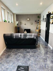 un sofá negro en una sala de estar con chimenea en Maison chez graz & virg en Calais