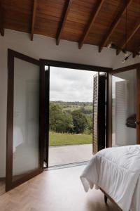 a bedroom with a bed and a large glass door at Cabanas Vinsanto in Bento Gonçalves
