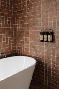 a bathroom with a bath tub and some bottles on a shelf at Cabanas Vinsanto in Bento Gonçalves