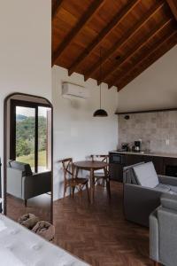 kuchnia i salon ze stołem i kanapą w obiekcie Cabanas Vinsanto w mieście Bento Gonçalves