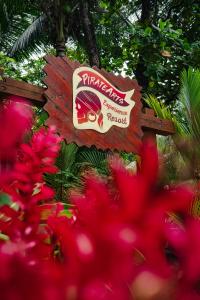 a sign for a restaurant with pink flowers in the foreground at PirateArts Experience Resort in Bocas del Toro