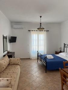a bedroom with a bed and a couch in it at ΞΕΝΟΔΟΧΕΙΟ ΑΚΡΩΤΗΡΙ in Platia Ammos