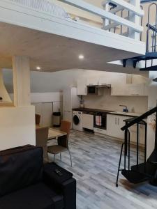 a living room with a couch and a kitchen at La tour du bonheur in Mantry
