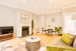 a living room with a couch and a fireplace at Primrose Hill Park in London