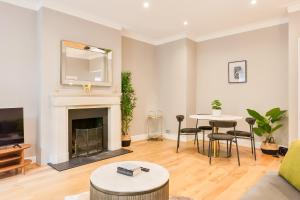 a living room with a fireplace and a table at Primrose Hill Park in London +25 photos