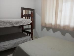 a bedroom with two bunk beds and a window at Casa B com Piscina Enseada Ubatuba Max06 Hosp in São Francisco do Sul