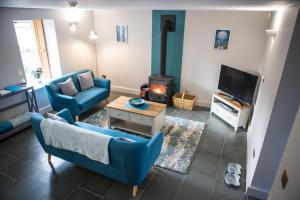 a living room with a blue couch and a fireplace at Vineyard Country Cottage in Llanerch-Aeron