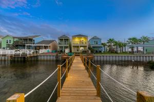 a wooden dock with houses on the water at Las Joyas Bayview Home in Port Isabel