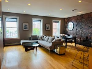 ein Wohnzimmer mit Sofa und Ziegelwand in der Unterkunft Boston North end Harbor View condo. FREE PARKING in Boston