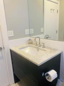 a bathroom with a sink and a toilet paper dispenser at Boston North end Harbor View condo. FREE PARKING in Boston