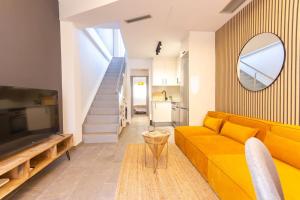 a living room with a yellow couch and a mirror at Duplex with terrace near Bcn in Terrassa