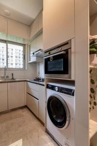a kitchen with a washing machine and a microwave at One Bedroom Apartment - Regent Hills, Mumbai Powai in Mumbai