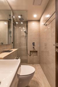 a bathroom with a shower and a toilet and a sink at One Bedroom Apartment - Regent Hills, Mumbai Powai in Mumbai