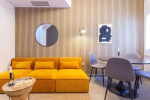 a living room with a yellow couch and a table at Duplex with terrace near Bcn in Terrassa