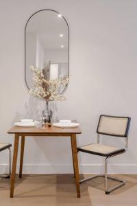 une table en bois avec un miroir et deux chaises dans l'établissement The Ladywell in Lewisham, à Londres