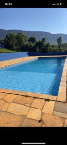 uma grande piscina com água azul em Pousada Nikimba em São Roque de Minas